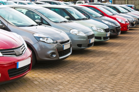 A used car sales forecourt, lots of cars in a row